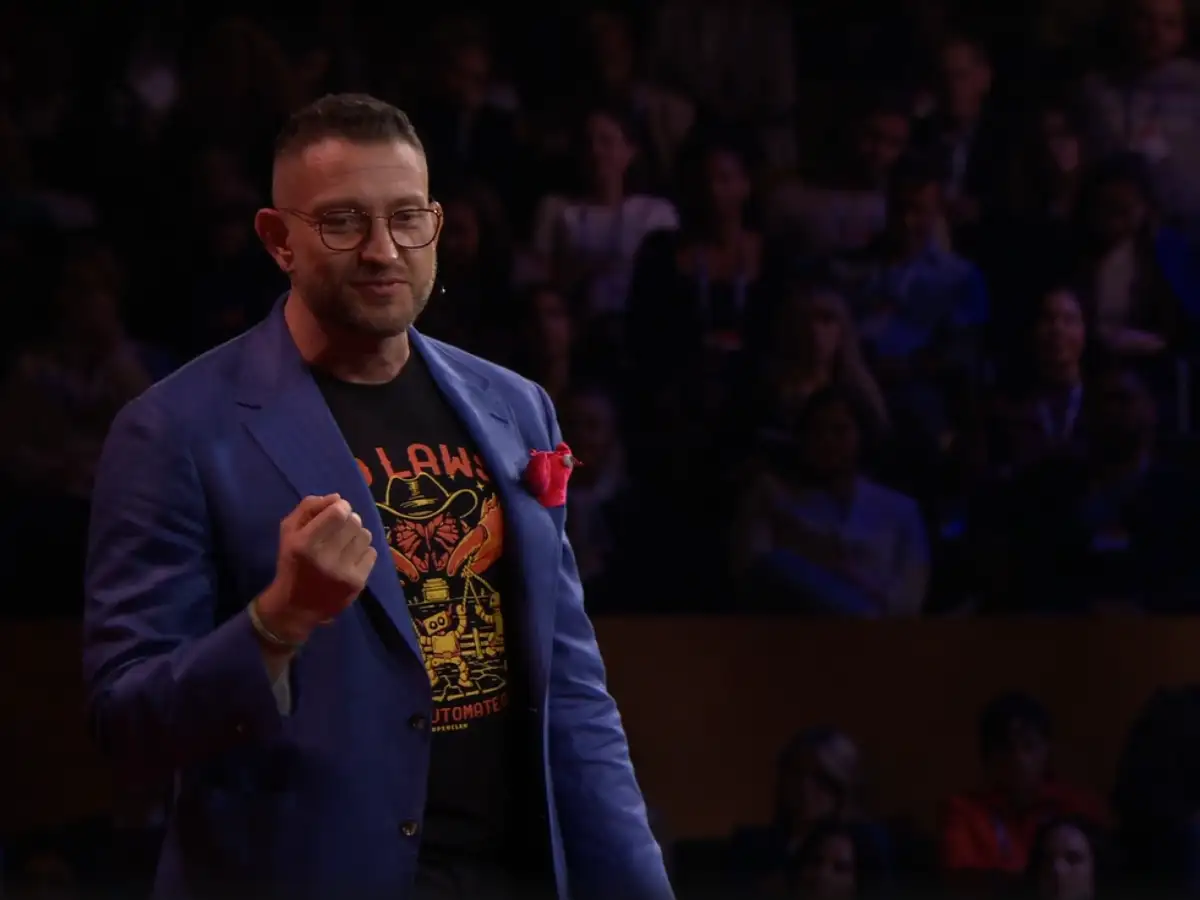 Peter Steinberger presenting OpenClaw at TED 2026, with a futuristic graphic of a robotic claw on a large screen.