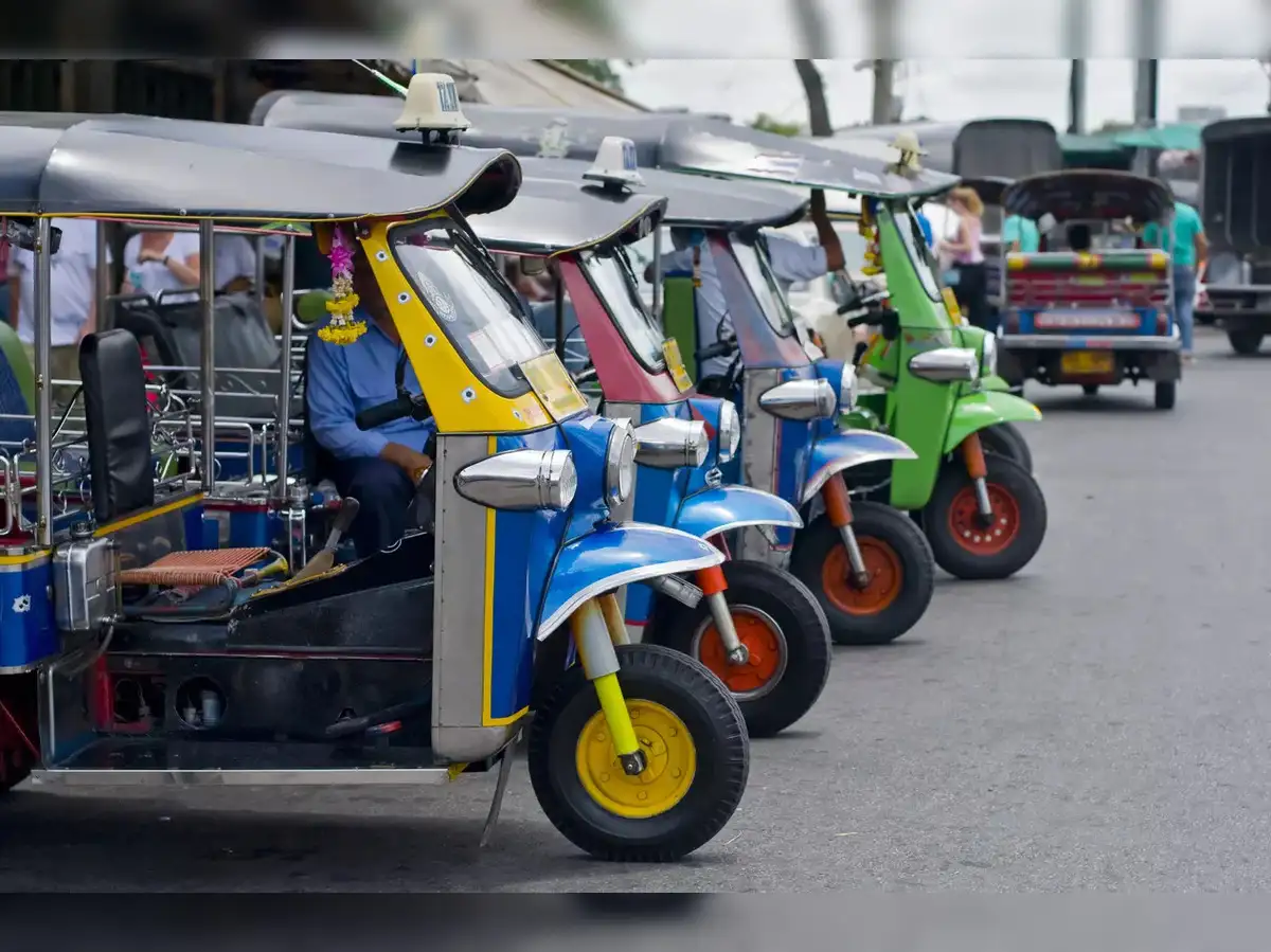 A smartphone displaying a generic battery app icon with an e-rickshaw in the background, symbolizing MeitY's action against specific battery management apps.
