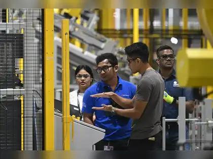 Workers operating machines at manufacturing facility