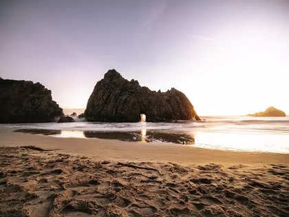 Young man on the rocks by the beach wearing underwear Stock Photo