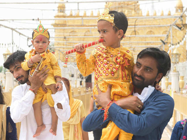 Hindu devotees carry their children dressed as Lord Krishna at the Durgiana Temple on the occasion of the 'Janmashtami' festival that marks Krishna's birthday in Amritsar.